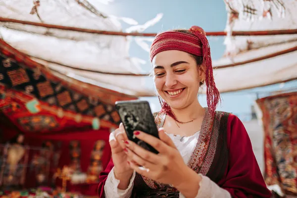 Một người chơi sử dụng điện thoại trong khung cảnh sôi động, thể hiện khả năng truy cập di động linh hoạt của QWE123.